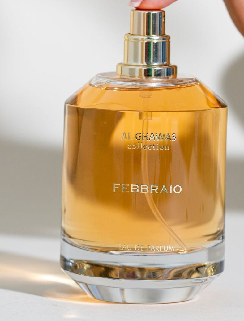 a person holding a bottle of perfume in their hand