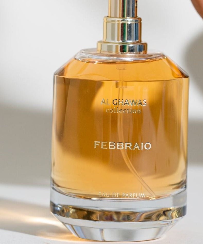 a person holding a bottle of perfume in their hand